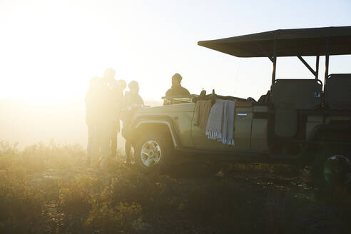 Safaritour-Gruppe trinkt Tee vor dem sonnigen Geländewagen - CAIF23942