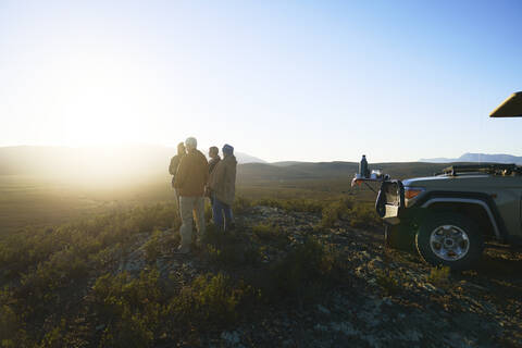 Safari-Reisegruppe genießt den idyllischen Sonnenaufgang vom Hügel Südafrikas, lizenzfreies Stockfoto