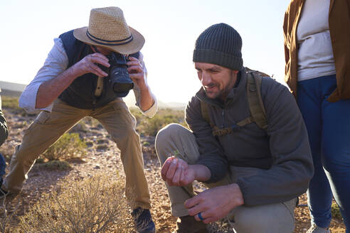 Safari-Führer erklärt einem Touristen mit Kamera die Pflanzen - CAIF23969