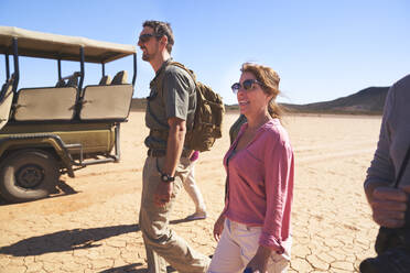 Safari-Reisegruppe beim Wandern in der sonnigen Wüste Südafrikas - CAIF24011