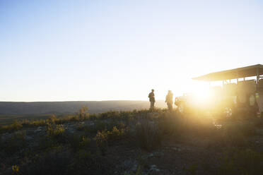 Safari-Reisegruppe auf einem sonnigen Hügel bei Sonnenaufgang Südafrika - CAIF24024