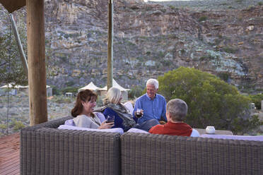 Ältere Freunde entspannen sich bei Wein auf der Hotelterrasse - CAIF24028
