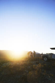 Safari-Reisegruppe auf einem sonnigen Hügel bei Sonnenaufgang Südafrika - CAIF24042