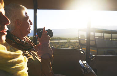 Älteres Paar mit Digitalkamera im Safari-Geländewagen - CAIF24049