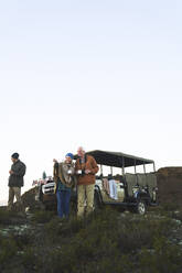 Älteres Paar auf Safari trinkt Tee auf einem Hügel - CAIF24061