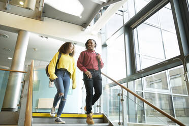 Lächelnde Studenten, die eine Treppe hinuntergehen - CAIF24129