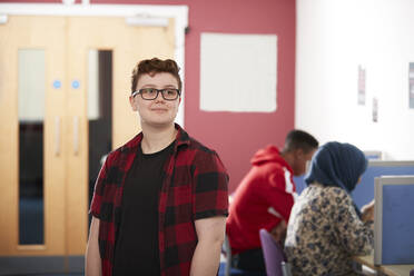 Portrait confident ambitious young male college student in library - CAIF24162