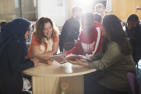 College-Studenten lernen gemeinsam in einem sonnigen Klassenzimmer - CAIF24172
