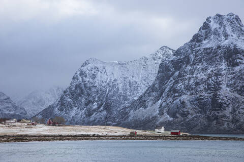 Schneebedeckte Berge über dem Dorf Flakstadpollen Lofoten Norwegen, lizenzfreies Stockfoto