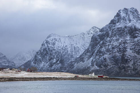 Schneebedeckte Berge über dem Dorf Flakstadpollen Lofoten Norwegen - CAIF24228