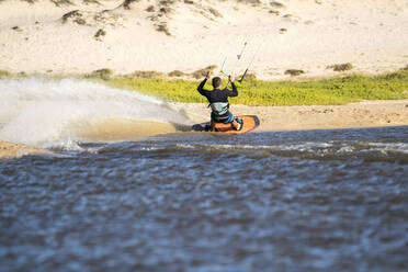 Professioneller männlicher Sportler beim Kiteboarding an einem sonnigen Tag in Mexiko - CAVF74777