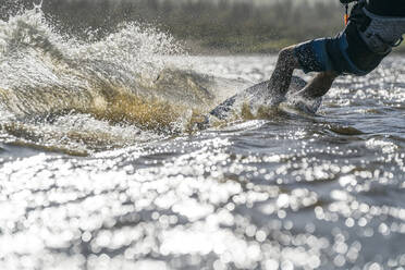 Waist-down male athlete kiteboarding in La Ventana, Mexico - CAVF74785