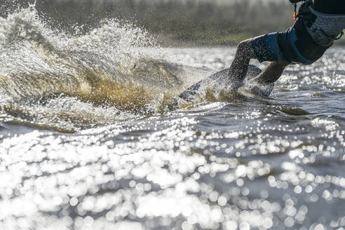 Taillierter männlicher Sportler beim Kiteboarden in La Ventana, Mexiko - CAVF74785