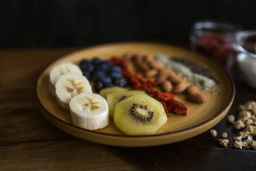 Healthy breakfast plate of fruit, berries and seeds with yogurt and granola - CAVF74860