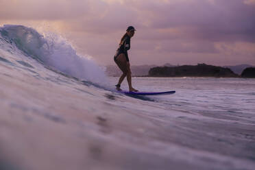 Young woman surfing at sunset - CAVF74869
