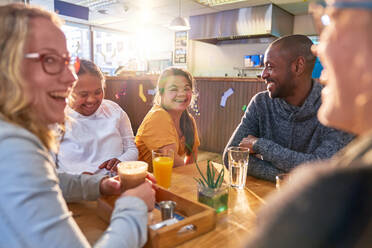 Junge Frauen mit Down-Syndrom lachen mit Freunden in einem Cafe - CAIF24358