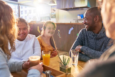 Happy young women with Down Syndrome in cafe with friends - CAIF24447