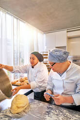 Koch und Student mit Down-Syndrom backen Brot in der Küche - CAIF24452