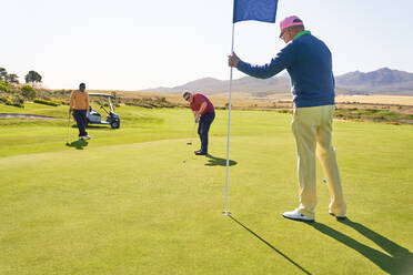 Männer auf sonnigem Golf-Putting-Green - CAIF24480