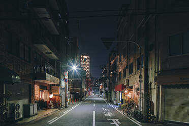 Nächtliche Szene einer leeren Straße und alter Einzelhandels- und Wohnblockgebäude, Osaka, Japan - ISF23783