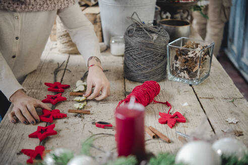 Frau bastelt Weihnachtsschmuck im Geschäft - ISF23827