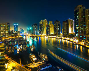 Nachtszene der Skyline der Stadt und Boote im Hafen, Dubai - ISF23859