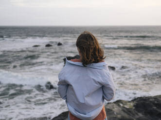 Junge Frau mit Blick auf das Meer - CAVF74990