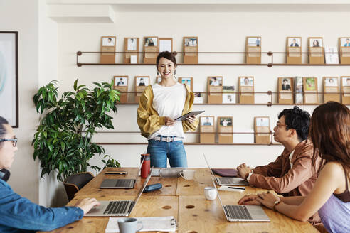 Eine Gruppe junger japanischer Berufstätiger arbeitet an Laptops in einem Co-Working Space. - MINF13744