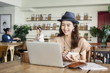 Group of young Japanese professionals working on laptop computers in a co-working space. - MINF13759