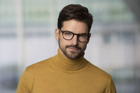 Porträt eines selbstbewussten Mannes mit Brille und gelbem Pullover, lizenzfreies Stockfoto