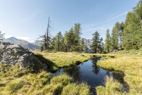 Teich und Wanderer im Hintergrund, Alpen, Graubünden, Schweiz - HBIF00042