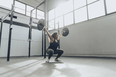 Young woman weightlifting in gym - MTBF00341
