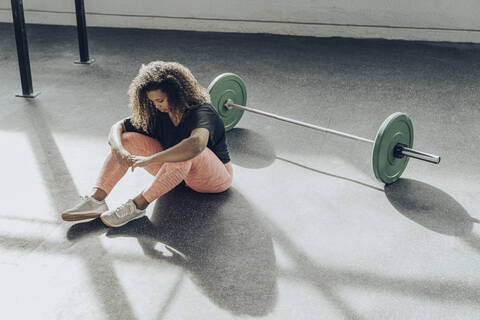 Junge Frau, die eine Pause vom Sport im Fitnessstudio macht, lizenzfreies Stockfoto