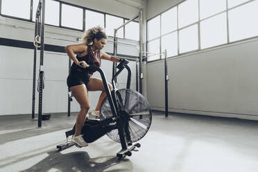 Junge Frau beim Airbike-Training im Fitnessstudio - MTBF00346