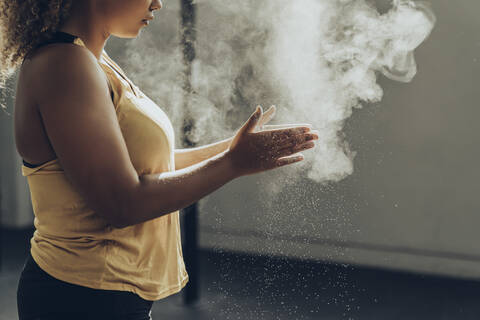 Sportliche Frau bereitet sich im Fitnessstudio auf ihr Training vor, lizenzfreies Stockfoto