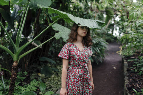 Female teenager under palm tree in Botanical Garden stock photo