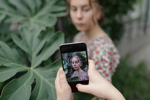 Bild auf Smartphone eines weiblichen Teenagers im Botanischen Garten - OGF00161