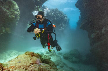 Taucher bei der Erkundung eines Canyons am Great Barrier Reef in Australien - CAVF75149