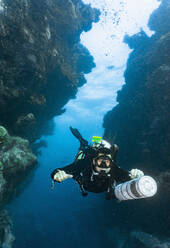 Taucher bei der Erkundung eines Canyons am Great Barrier Reef in Australien - CAVF75156