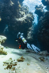 Scuba diver exploring a canyon at the great barrier reef in Australia - CAVF75157
