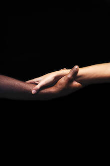 Männliche und weibliche Hände mit unterschiedlichen Hauttönen halten sich gegenseitig - CAVF75308