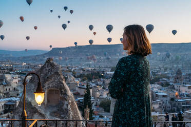 Eine Frau genießt einen magischen Morgen im Heißluftballon in Kappadokien - CAVF75355