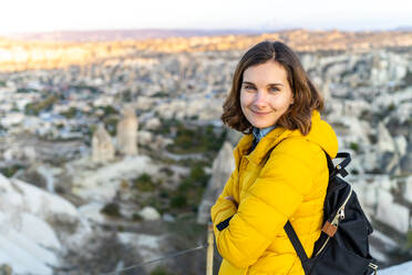 Reisende Frau in leuchtend gelber Jacke bei Sonnenuntergang in der Zentraltürkei - CAVF75370