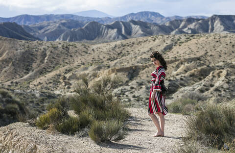 Modische Frau in gestreiftem Kleid in einer Landschaft, Almeria, Spanien, lizenzfreies Stockfoto