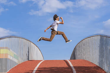 Dancer jumping on bridge, mid air - DLTSF00559