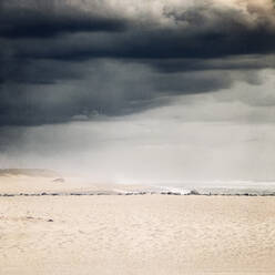 Frankreich, Nouvelle-Aquitaine, Contis, Graue Gewitterwolken über dem Strand von Contis Plage - DWIF01078