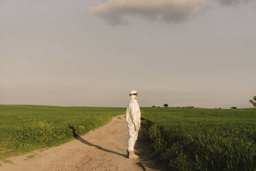 Mann mit Schutzanzug und Maske auf dem Lande - ERRF02630