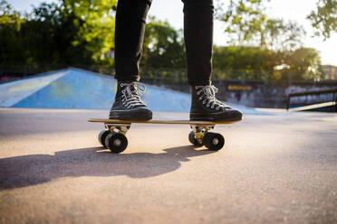 Young woman standing on skateboard - GIOF08018