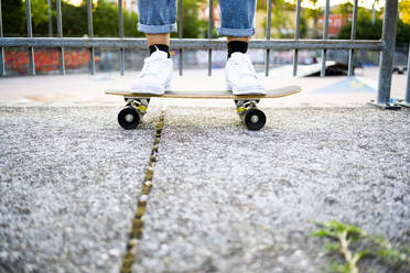 Young woman standing on skateboard - GIOF08036