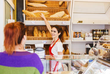 Junge Frau bedient Kundin in einer Bäckerei - LJF01326